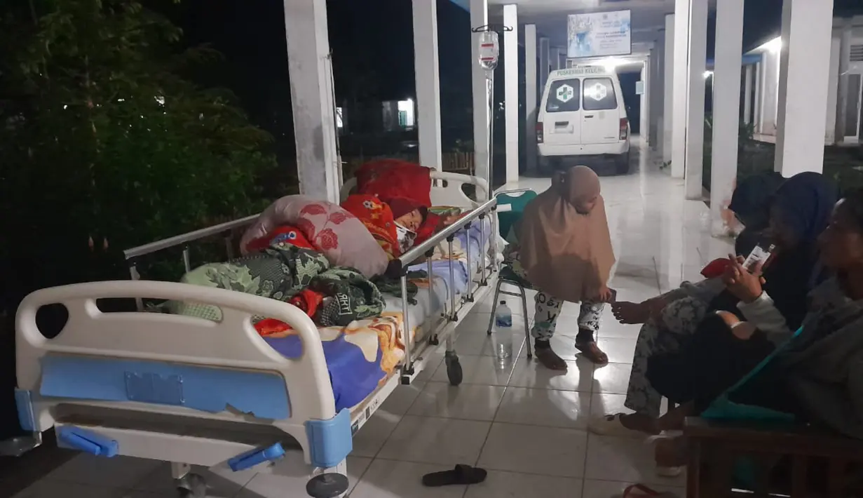 Warga berlindung di luar ruangan rumah sakit setelah gempa mengguncang Desa Muara Sikabaluan, Pulau Siberut, Kabupaten Kepulauan Mentawai, Provinsi Sumatra Barat, Selasa (25/4/2023) dini hari. Badan Meteorologi Klimatologi dan Geofisika (BMKG) memutakhirkan kekuatan gempa Kepulauan Mentawai yang sebelumnya magnitudo 7,3 menjadi magnitudo 6,9. (BAMBANG SAGURUNG/AFP)