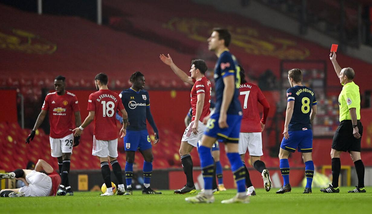 Wasit memberikan kartu merah kepada pemain Southampton, Alex Jankewitz, saat melawan Manchester United pada laga Liga Inggris di Stadion Old Trafford, Selasa (2/2/2021). Setan Merah menang dengan skor 9-0. (Laurence Griffiths/Pool via AP)