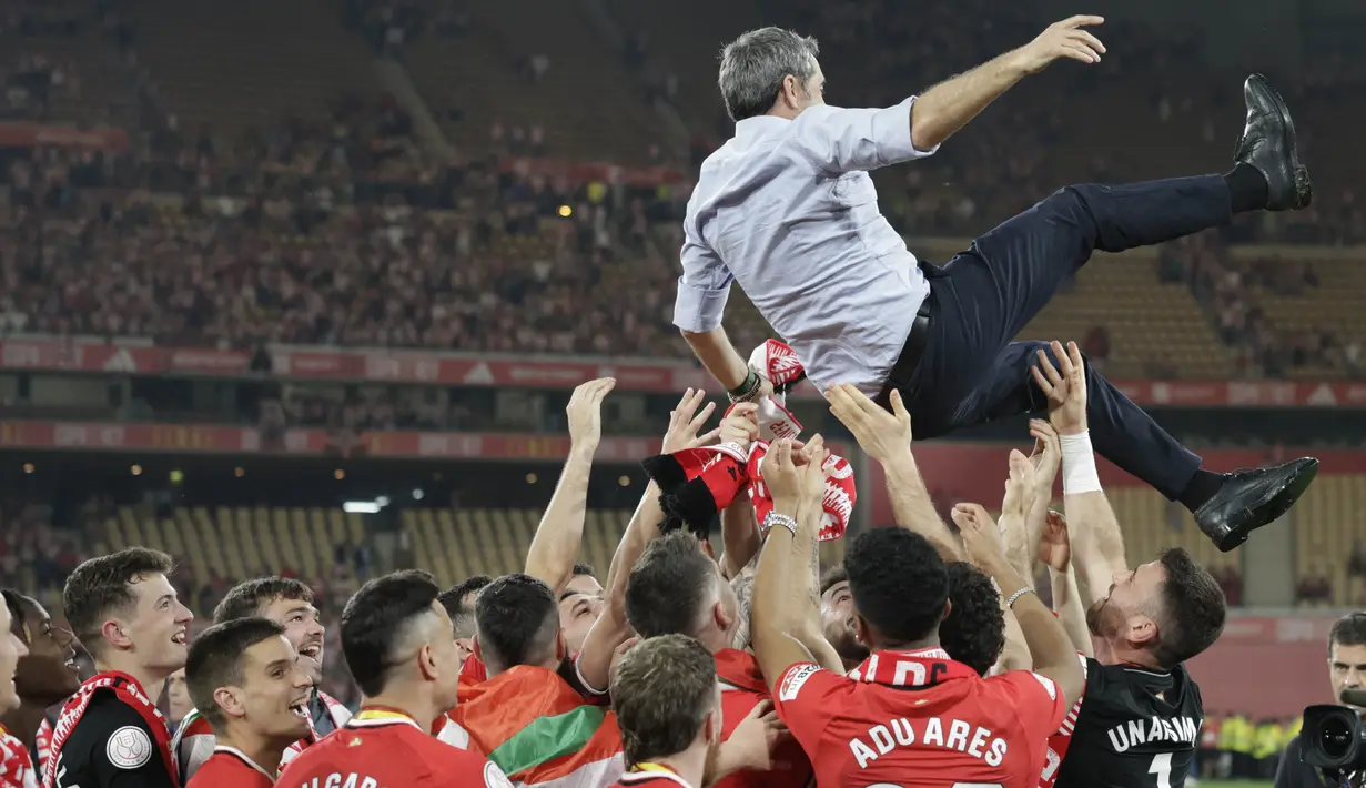 Pelatih Athletic Bilbao, Ernesto Valverde, diangkat para pemainnya setelah menjuarai Copa del Rey di Stadion Olimpico de Sevilla, Minggu (7/4/2024). (AFP/Jaime Reina)