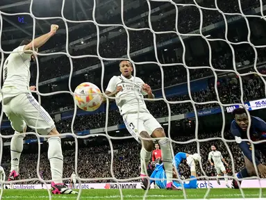 Pemain Real Madrid, Eder Militao (tengah) mencetak gol bunuh diri pada laga leg pertama semifinal Copa Del Rey 2022/2023 melawan Barcelona di Santiago Bernabeu, Madrid, Jumat (03/03/2023) WIB. Gol ini menjadi satu-satunya gol yang berhasil memenangkan Barcelona dengan skor 1-0. (AFP/Javier Soriano)