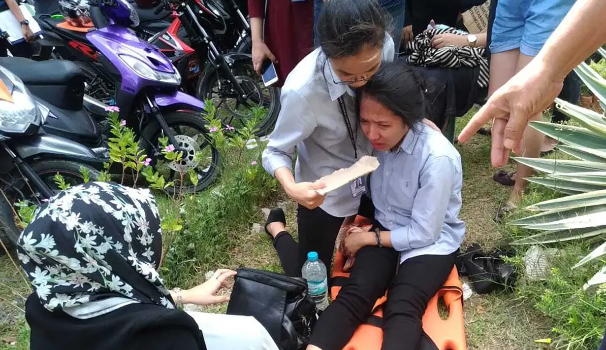Seorang wanita menangis saat dievakuasi setelah gempa kuat  di Kota Davao, Filipina (29/10/2019). Sejauh ini tak ada kerusakan atau korban yang dilaporkan. (AP Photo)