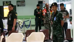 Seorang tentara Thailand berjaga-jaga saat petugas polisi menyelidiki lobi Rumah Sakit Phramongkutklao, Bangkok, (22/5). Wakil kepala polisi Thailand mengatakan, penyidik menemukan jejak baterai dan kabel di lokasi ledakan. (AP Photo/Sakchai Lalit)