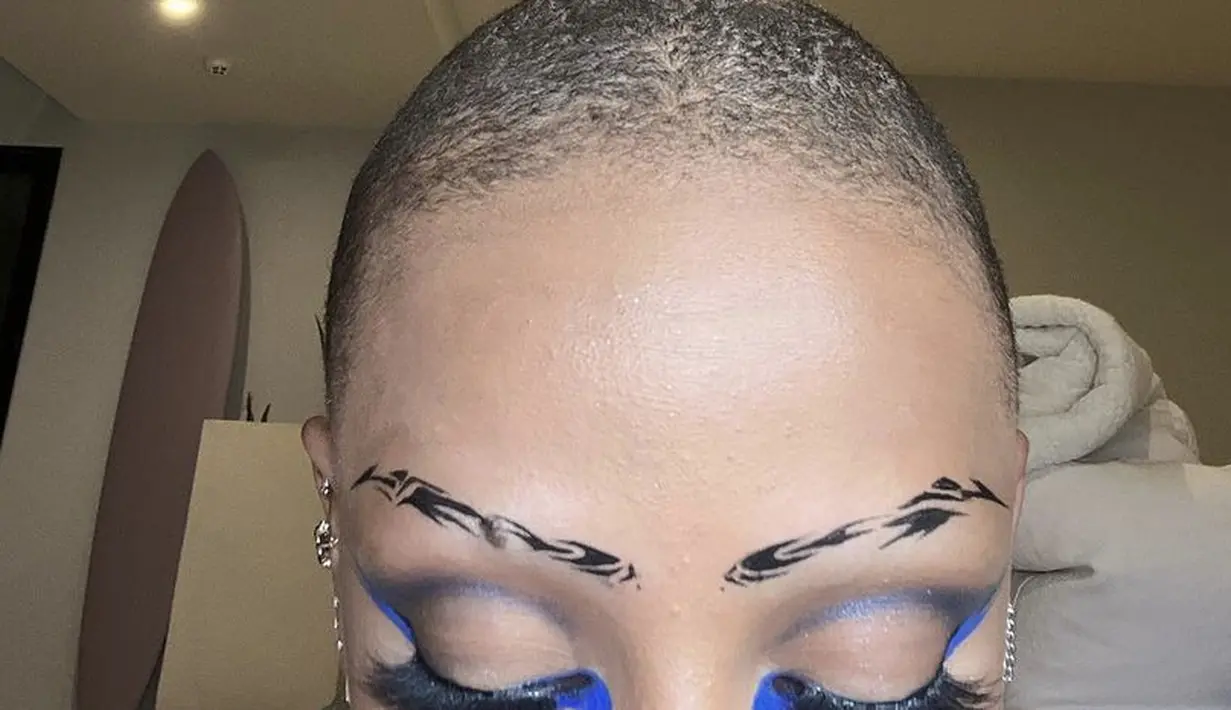 <p>Ia juga berkreasi dengan gambar abstrak hitam, dipadukan eyeshadow biru tipis dan eyeliner wings biru neon.@dojacat</p>