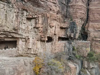 Foto dari udara pada 28 Oktober 2020 ini menunjukkan wisatawan menyusuri jalur di tebing dekat Waduk Xiagou yang berada di Chaiguan, Kota Shahe, Provinsi Hebei, China utara. Jalur tebing pada dinding Waduk Xiagou ini digali secara manual pada 1970-an. (Xinhua/Mu Yu)