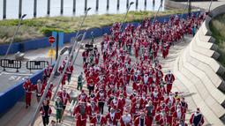 Sejumlah pelari berkostum Sinterklas berlomba dalam acara fun run 5 km di jalanan Barcelona, Spanyol pada Minggu (22/12/2024) waktu setempat. (AFP/Josep Lago)
