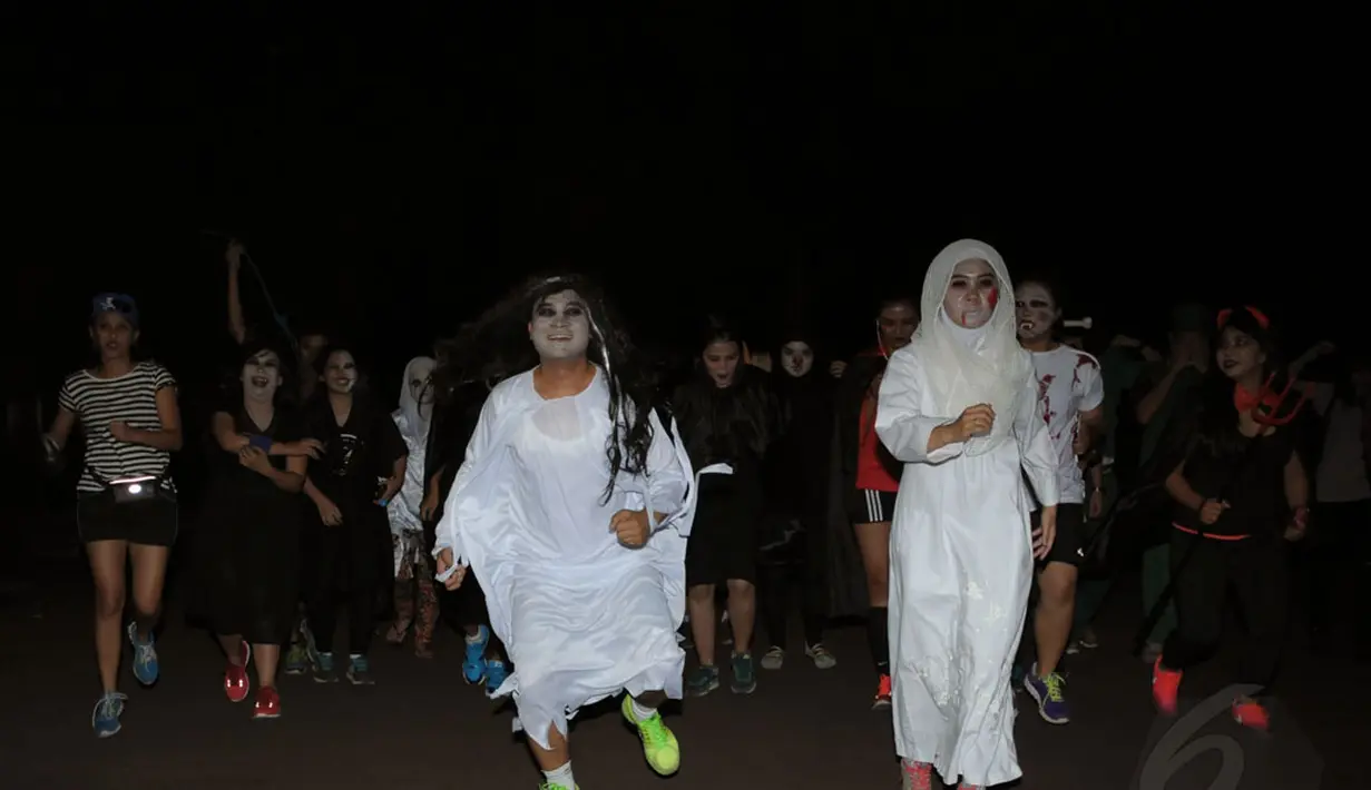 Beberapa orang berlari menggunakan kostum menyeramkan saat merayakan perayaan Halloween di kawasan Stadion Gelora Bung Karno, Jakarta, Kamis (30/10/2014). Halloween merupakan tradisi perayaan malam 31 Oktober. (Liputan6.com/Helmi Fithriansyah)