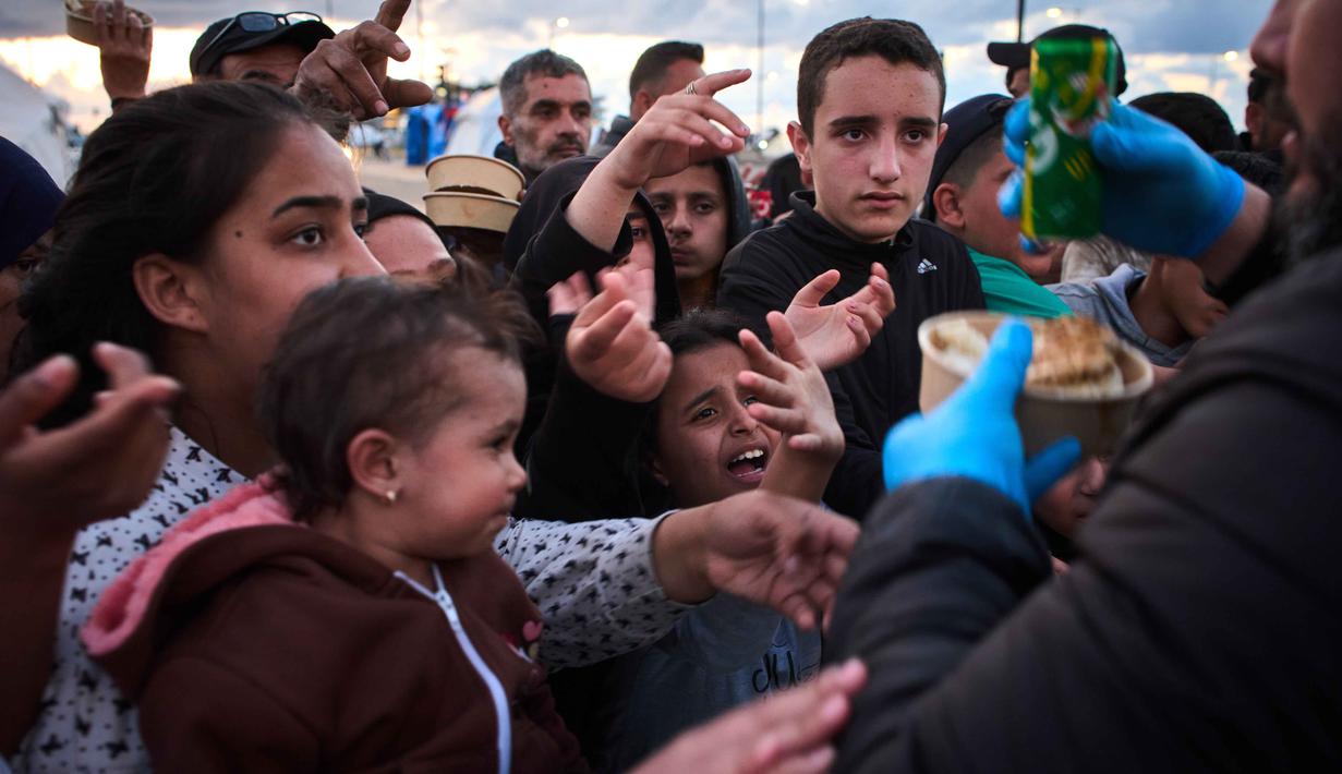 Koordinator Bantuan Darurat Perserikatan Bangsa Bangsa (PBB), Tom Fletcher, pada 31 Maret 2026, menyebut setidaknya 1.240 orang tewas dan 3.500 lainnya terluka, termasuk perempuan, anak-anak, dan petugas penyelamat. Tampak dalam foto, para pengungsi menunggu untuk menerima makanan sumbangan di samping tenda-tenda yang mereka gunakan sebagai tempat berlindung setelah melarikan diri dari serangan udara Israel di Lebanon selatan, Beirut, Lebanon, Senin 6 April 2026. (AP Photo/Emilio Morenatti)