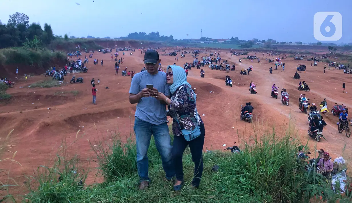 Warga beraktivitas di tanah lapang di kawasan Cipayung, Depok, Jawa Barat, Kamis (11/6/2020). Kurang tegasnya sanksi serta minimnya kesadaran masyarakat akan protokol kesehatan terkait covid-19 menyebabkan kawasan itu menjadi tempat berkerumun warga setiap sore hari. (Liputan6.com/Immanuel Antonius)