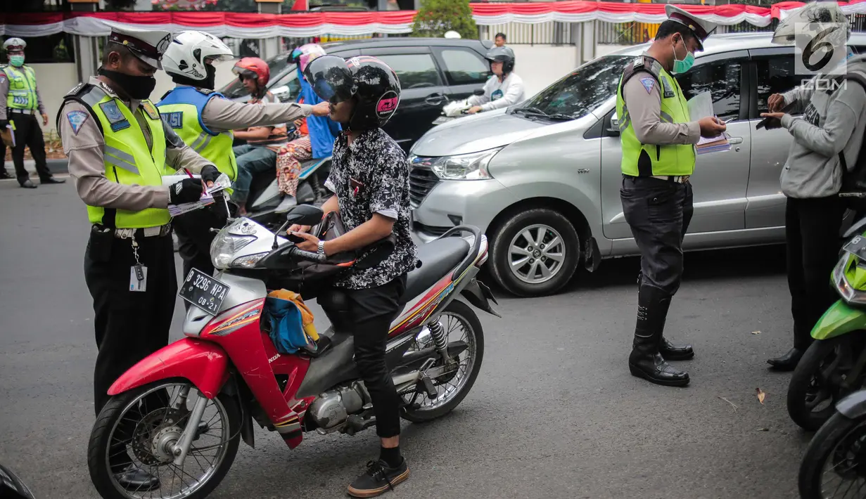 Polisi lalu lintas menindak pengendara sepeda motor saat razia Operasi Patuh Jaya 2019 di kawasan Kemanggisan, Jakarta, Kamis (29/8/2019). Diketahui, Operasi Patuh Jaya 2019 di wilayah hukum Polda Metro Jaya mulai digelar hari ini hingga 11 September 2019. (Liputan6.com/Faizal Fanani)