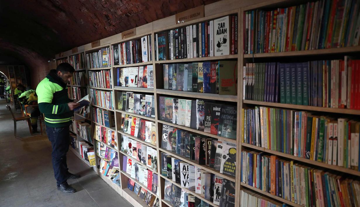 Petugas kebersihan membaca buku di perpustakan tempat mereka bekerja di distrik Cankaya, Ankara, Turki (9/1).Beberapa petugas ini membuat band bernama "Grup Tin", dengan menggunakan tempat sampah dan barang bekas sebagai alat musik. (AFP Photo/Adem Altan)