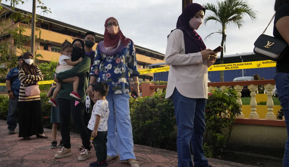 Orang-orang mengantre memasuki TPS untuk memberikan suara mereka selama pemilihan umum (pemilu) di Seberang Perai, negara bagian Penang, Malaysia, Sabtu (19/11/2022). Pemungutan suara untuk Pemilihan Umum ke-15 Malaysia telah dimulai secara resmi hari ini. (AP Photo/Vincent Thian)
