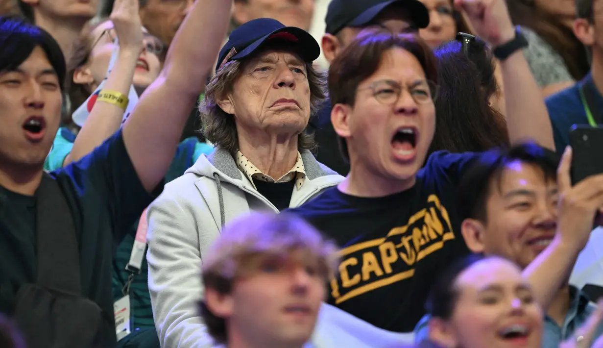 Mick Jagger tampak asyik dengan olahraga pertarungan yang menampilkan adu pedang ini, sambil menatap tajam ke arah kompetisi yang berlangsung di depannya. (Fabrice COFFRINI / AFP)