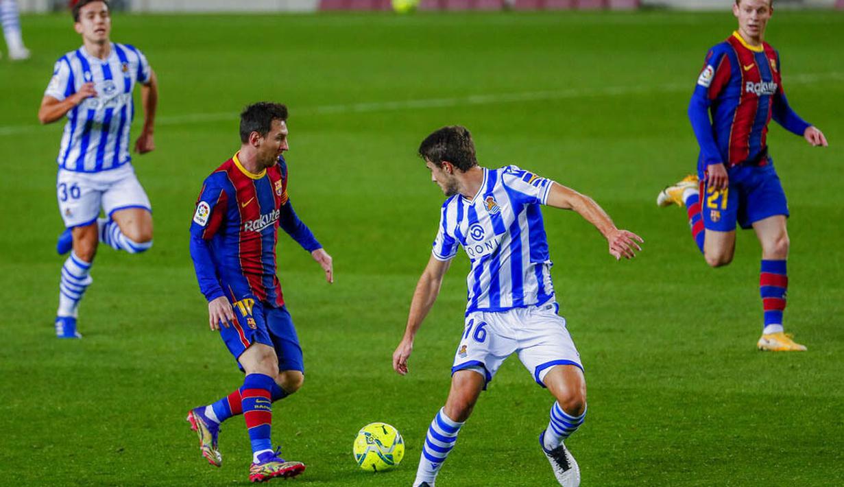 Striker Barcelona, Lionel Messi, berusaha melewati pemain Real Sociedad, Ander Guevara, pada laga Liga Spanyol di Stadion Camp Nou, Kamis (17/12/2020). Barcelona menang dengan skor 2-1. (AP/Joan Monfort)