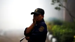 Seorang petugas keamanan menutup hidungnya saat dilakukan pengasapan di sebuah universitas di Bangkok, Selasa (13/9). Sebelumnya Kementerian Kesehatan Thailand menyatakan, ada 21 kasus baru virus Zika yang terjadi di Bangkok. (REUTERS/Athit Perawongmetha)