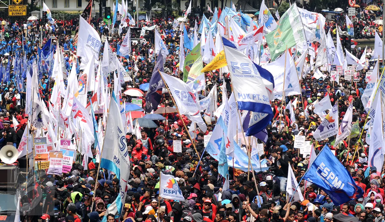 Kibaran bendera organisasi buruh mewarnai aksi perayaan hari Buruh Internasional di Kawasan Patung Patung Arjuna Wiwaha, Jakarta, Senin (5/1). Ribuan massa buruh ikut dalam perayaan Hari Buruh Internasional 2017. (Liputan6.com/Helmi Fithriansyah)