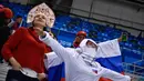 Fans wanita Rusia menunggu dimulainya pertandingan hoki es semifinal antara Republik Ceko dan Rusia selama Olimpiade Musim Dingin Pyeongchang 2018 di Gangneung Hockey Centre di Gangneung pada (23/2). (AFP Photo/Brendan Smialowski)