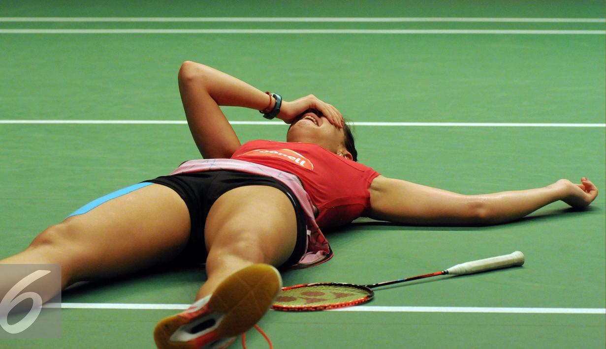 Pebulutangkis Spanyol, Carolina Marin tergeletak sambil menutup wajah usai menyelesaikan laga melawan Saina Nehwal (India) di final BWF World Championships 2015 di Jakarta, Minggu (16/8/2015). Carolina unggul 21-16. 21-19.(Liputan6.com/Helmi Fithriansyah)