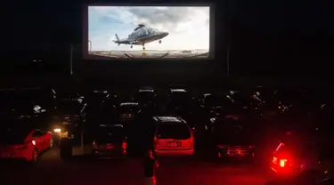 Puluhan mobil terparkir di depan layar bioskop saat pemutaran film drive-in di Family Drive-in di Virginia, 10 Agustus 2018. Menonton film di luar ruangan atau drive-in merupakan bagian penting dalam industri hiburan di Amerika. (AFP PHOTO/Nicholas Kamm)