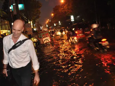 Salah satu warga asing tersenyum saat melintasi kawasan Kemang yang dilanda banjir pada Senin, (11/8/2014). (Liputan6.com/Miftahul Hayat)