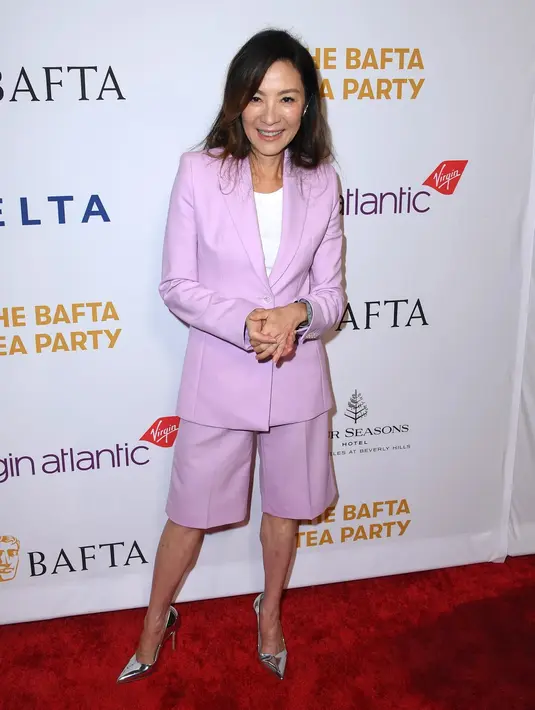<p>Michelle Yeoh mengenakan setelan berwarna ungu muda dari Off-White. Ini adalah momen saat ia menghadiri BAFTA Tea Party. Foto: Vogue.</p>