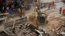 Sebuah alat berat dikerahkan untuk upaya pencarian korban di reruntuhan bangunan yang hancur akibat ledakan yang terjadi Rio de Janeiro, Brasil, Senin (19/10/2015). Ledakan diduga berasal dari kebocoran gas sebuah bangunan. (REUTERS/Pilar Olivares)