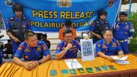 Direktur Polisi Air Polda Riau memperlihatkan foto TKI ilegal yang diselundupkan warga Bengkalis ke Indonesia. (Liputan6.com/M Syukur)