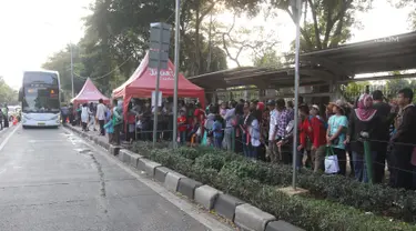 Warga antre untuk menaiki bus tingkat wisata keliling Ibu Kota di kawasan Monas, Jakarta, Sabtu (16/6). Libur Hari Raya Idul Fitri dimanfaatkan oleh sebagian masyarakat Jakarta untuk berlibur ketempat wisata bersama keluarga. (Liputan6.com/Arya Manggala)