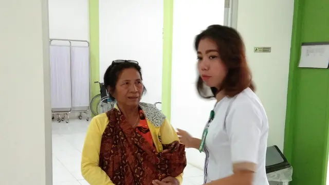 Seorang tenaga kesehatan di Puskesmas Jagoi Babang, Bengkayang, Kalimantan Barat membantu warga yang membawa anaknya untuk berobat