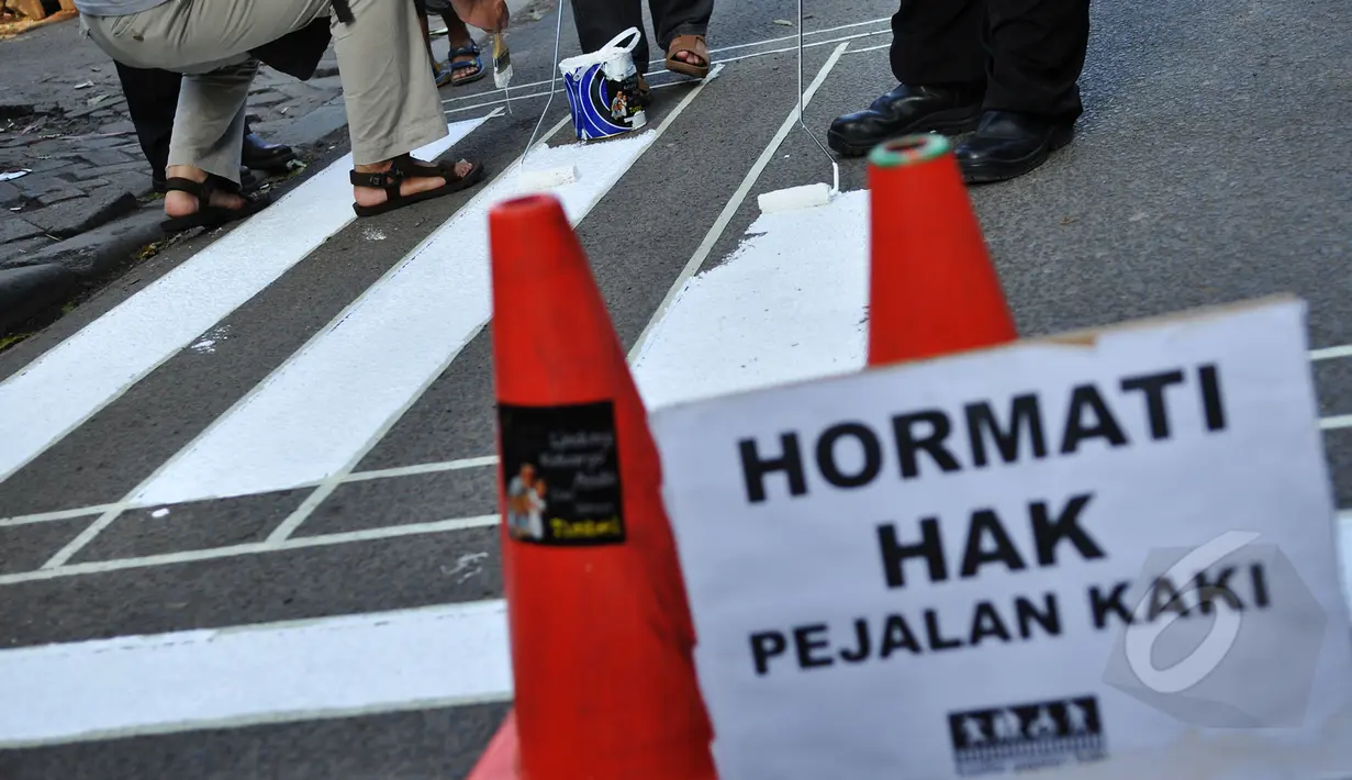Kurangnya perhatian akan hak para pejalan kaki membuat para relawan ini untuk membuat jalur zebra cross di depan Stasiun Sudirman, Jakarta, Jumat (13/3/2015). (Liputan6.com/Faizal Fanani)