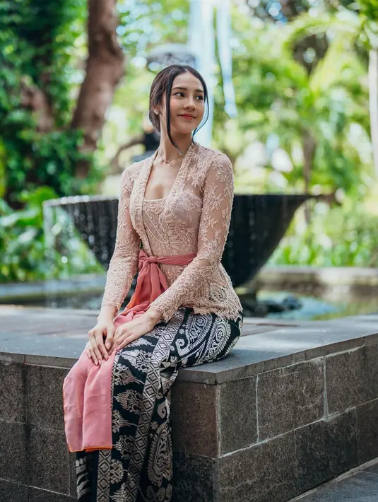 Anya Geraldine terlihat anggun dalam balutan kebaya Bali berwarna nude. Kebaya tersebut ia padukan bersama obi berwarna pink salmon. Sementara untuk bawahan, Anya memilih kain songket berwarna hitam-emas. [@anyageraldine].