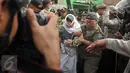 Petugas membawa seorang perempuan saat penggusuran kawasan Pasar Ikan, Penjaringan, Jakarta, Senin (11/4). Para warga yang didominasi perempuan itu ikut menolak penggusuran kawasan tersebut. (Liputan6.com/Gempur M Surya)