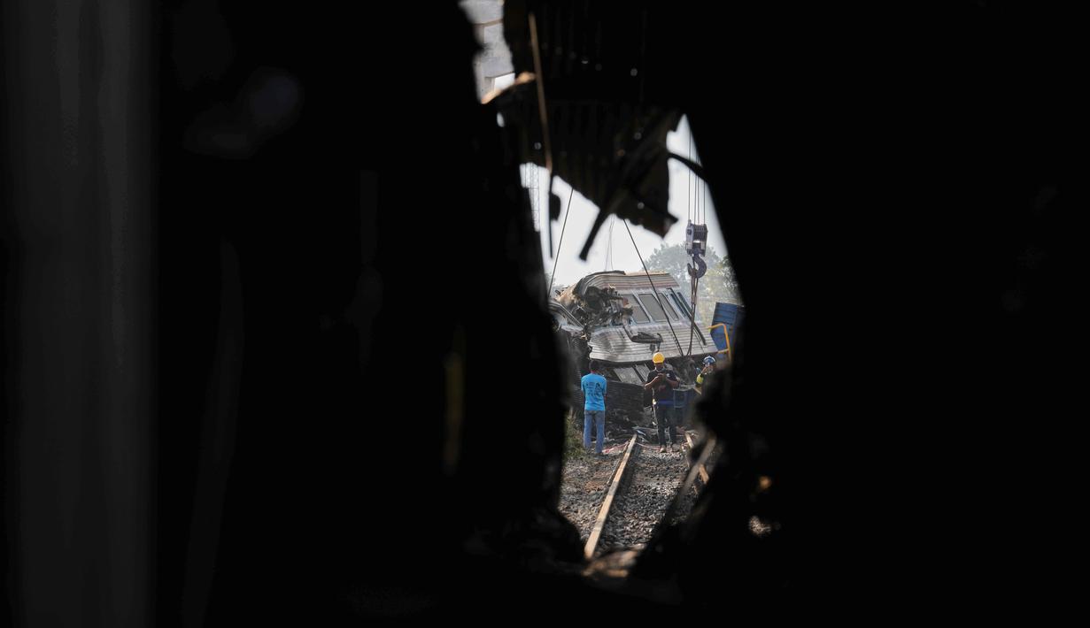 Para penyelamat terlihat di antara reruntuhan setelah sebuah crane atau derek konstruksi jatuh menimpa kereta penumpang di provinsi Nakhon Ratchasima, Thailand, Rabu 14 Januari 2026. Sebuah crane atau derek proyek jatuh dan menimpa kereta yang sedang melaju di Distrik Sikhio, Provinsi Nakhon Ratchasima, Thailand. (AP Photo/Sakchai Lalit)