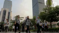 Pekerja berjalan kaki di sepanjang Jalan Jenderal Sudirman, Jakarta, Senin (10/6/2024). (Liputan6.com/Herman Zakharia)