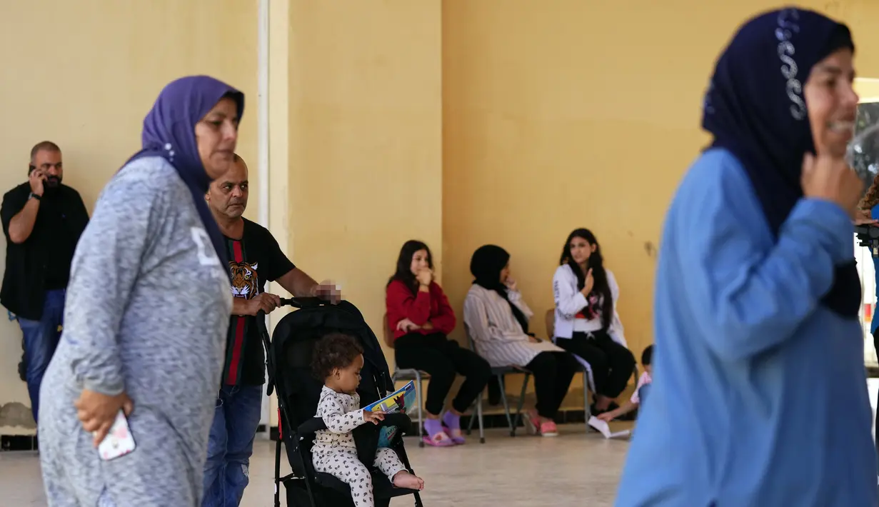 <p>Warga yang mengungsi dari Lebanon selatan, duduk di sebuah sekolah yang digunakan sebagai tempat berlindung di kota pelabuhan selatan Tyre, Lebanon, Jumat, 20 Oktober 2023. (AP Photo/Hassan Ammar)</p>