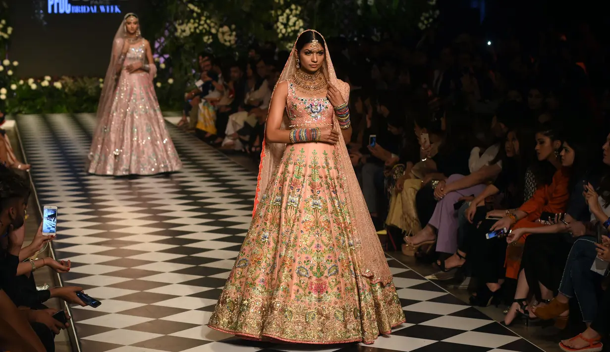 Para model berjalan di atas catwalk mengenakan pakaian tradisional Pakistan rancangan Rema dan Shehrbano selama peragaan busana yang digelar oleh Loreal Paris Pakistan Fashion Design Council di Lahore, Selasa (4/9). (AP Photo / K.M Chaudary)
