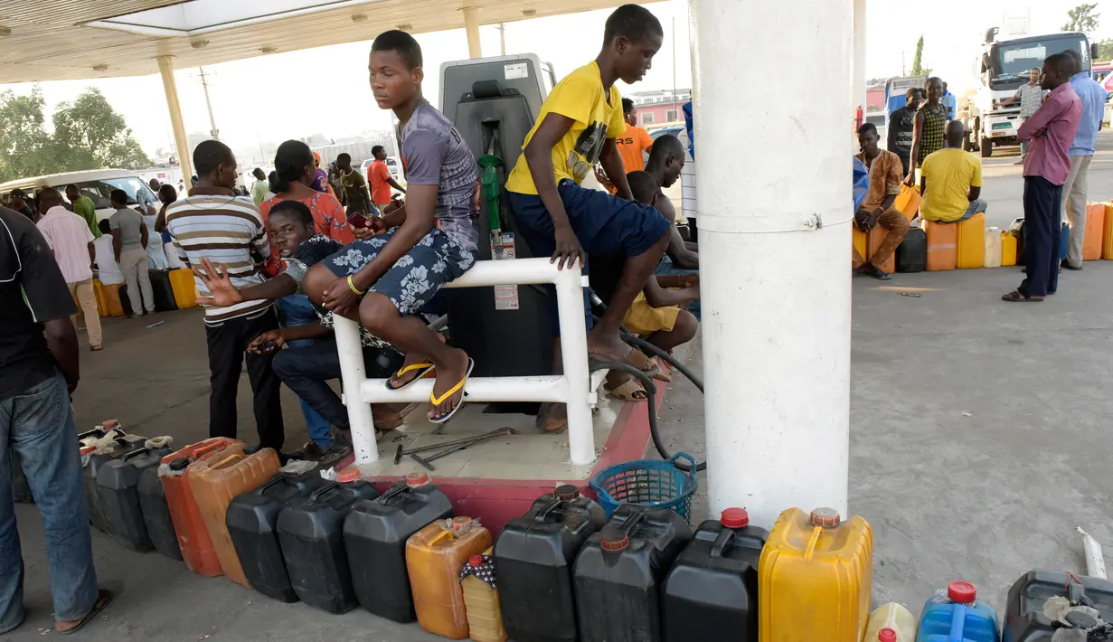 Warga Nigeria tampak menunggu saat antre mengisi bahan bakar di sebuah SPBU di Lagos, Nigeria, Selasa (1/12). Krisis bahan bakar yang telah melanda Nigeria dalam beberapa bulan terakhir menyebabkan antrean panjang di SPBU. (AFP PHOTO/PIUS Utomi EKPEI)
