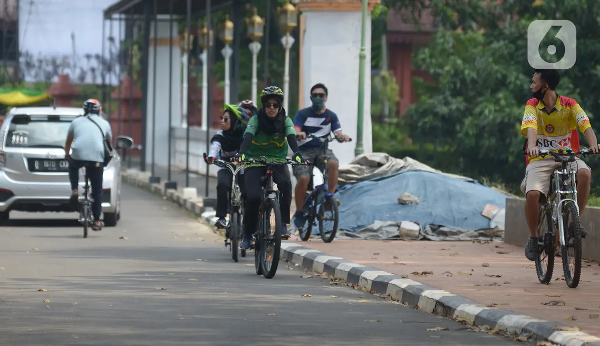 Pengunjung menaiki sepeda di Taman Mini Indonesia Indah, Jakarta, Kamis (20/8/2020). Warga memanfaatkan momen libur panjang Tahun Baru islam 1442 H ke tempat rekreasi yang dekat karena masih situasi pandemi Corona (COVID-19) dengan menjaga protokol kesehatan. (merdeka.com/Imam Buhori)