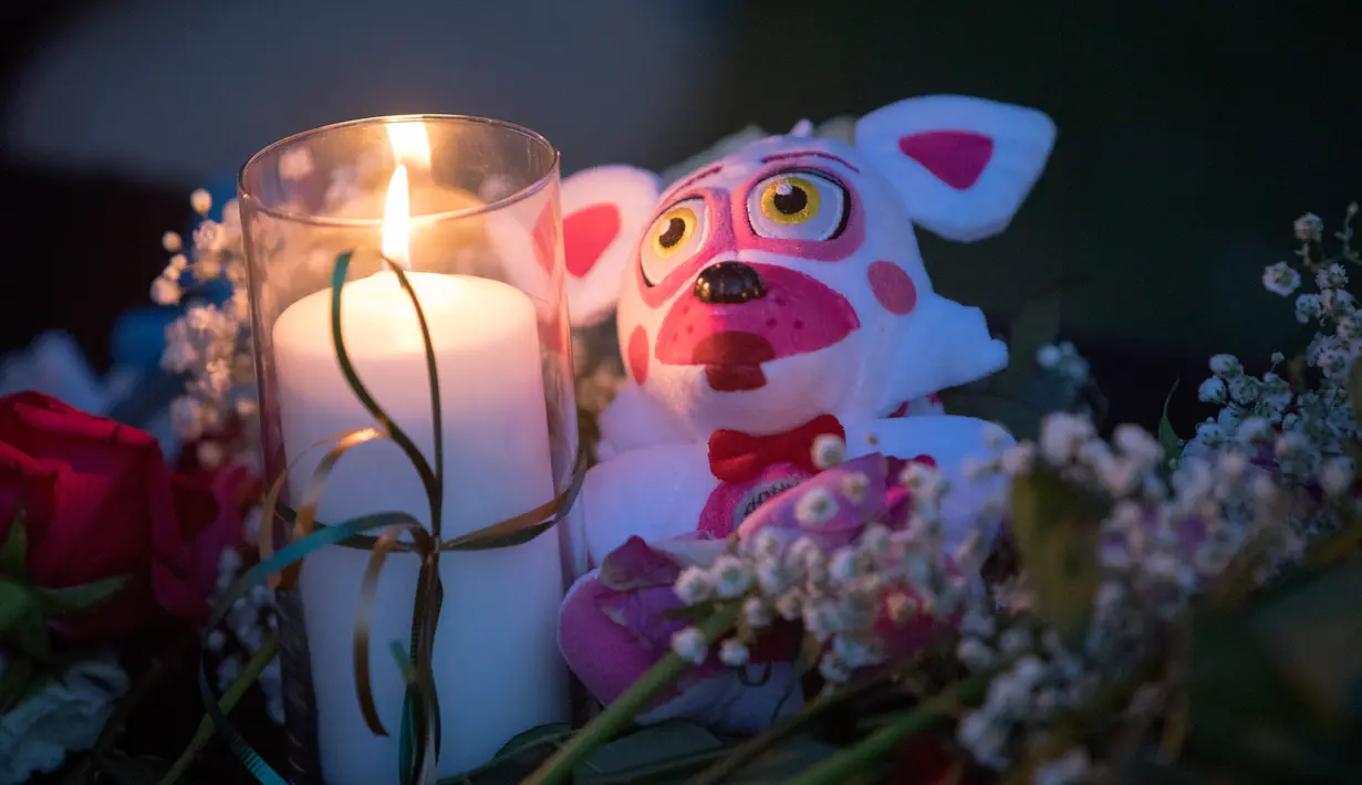 Lilin, bunga, dan boneka binatang menjadi simbol duka dalam aksi mengenang korban penembakan di sekolah Santa Fe, Texas, Amerika serikat, Jumat (18/5). Sebagian besar korban tewas dalam penembakan Texas merupakan para siswa. (AFP)