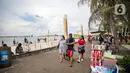 Wisatawan berjalan di Pantai Ancol, Jakarta, Sabtu (25/12/2021). Libur Natal dimanfaatkan masyarakat berwisata ke Pantai Ancol, Kawasan Pantai Ancol merupakan salah satu objek wisata yang kerap menjadi tujuan wisatawan saat mengisi waktu liburan. (Liputan6.com/Faizal Fanani)