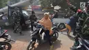 Seorang wanita menggunakan sepedah motor menyelamatkan diri saat terjadi gempa susulan di Tanjung pulau Lombok, NTB, Kamis (9/8).Gempa susulan tersebut menyebabkan kepanikan di antara pengungsi yang berlindung.(AFP/ ADEK BERRY)