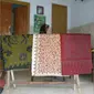 Maisun, perajin batik Tanjung Bumi, sedang melihatkan batik yang sedang dia garap.