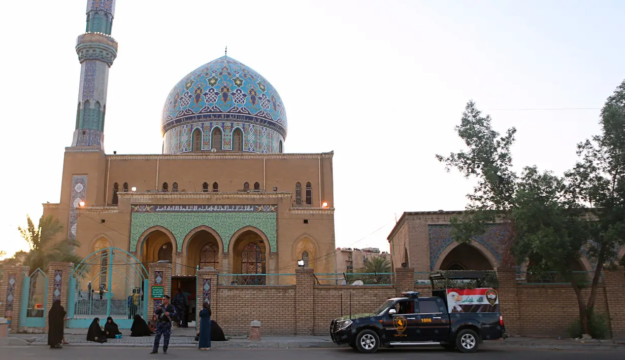Petugas keamanan berjaga di luar masjid saat umat muslim melaksanakan salat Idul Fitri di Baghdad, Irak, Selasa (4/6/2019). Selain Irak, sejumlah negara juga merayakan Hari Raya Idul Fitri hari ini. (AP Photo/Khalid Mohammed)