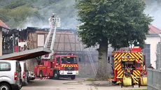 Petugas pemadam kebakaran bekerja memadamkan api setelah kebakaran di sebuah rumah penyandang disabilitas di Wintzenheim dekat Colmar, Prancis timur, pada 9 Agustus 2023. (AFP/Sébastien Bozon)