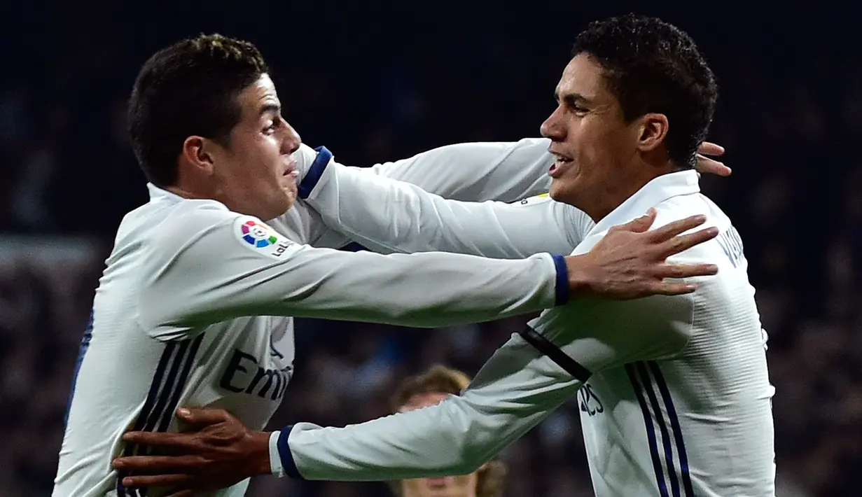 Bek Real Madrid, Raphael Varane (kanan) merayakan selebrasi bersama James Rodriguez usai mencetak gol ke gawang Sevilla pada 16 besar Copa del Rey di Santiago Bernabeu, Spanyol (5/1). Madrid menang atas Sevilla 3-0. (AFP Photo/Gerard Julien)