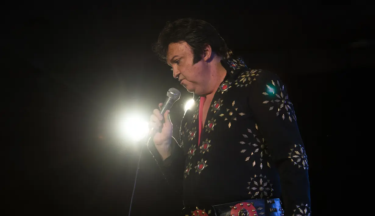 Kontestan yang bernama Neil Vincent tampil diatas panggung saat mengikuti Kejuaraan Elvis Eropa di Hilton Metropole Hotel di Birmingham, Inggris (5/1). Kompetisi mirip penyanyi legendaris Elvis Presley ini digelar setiap tahunnya. (AFP Photo/Oli Scarff)