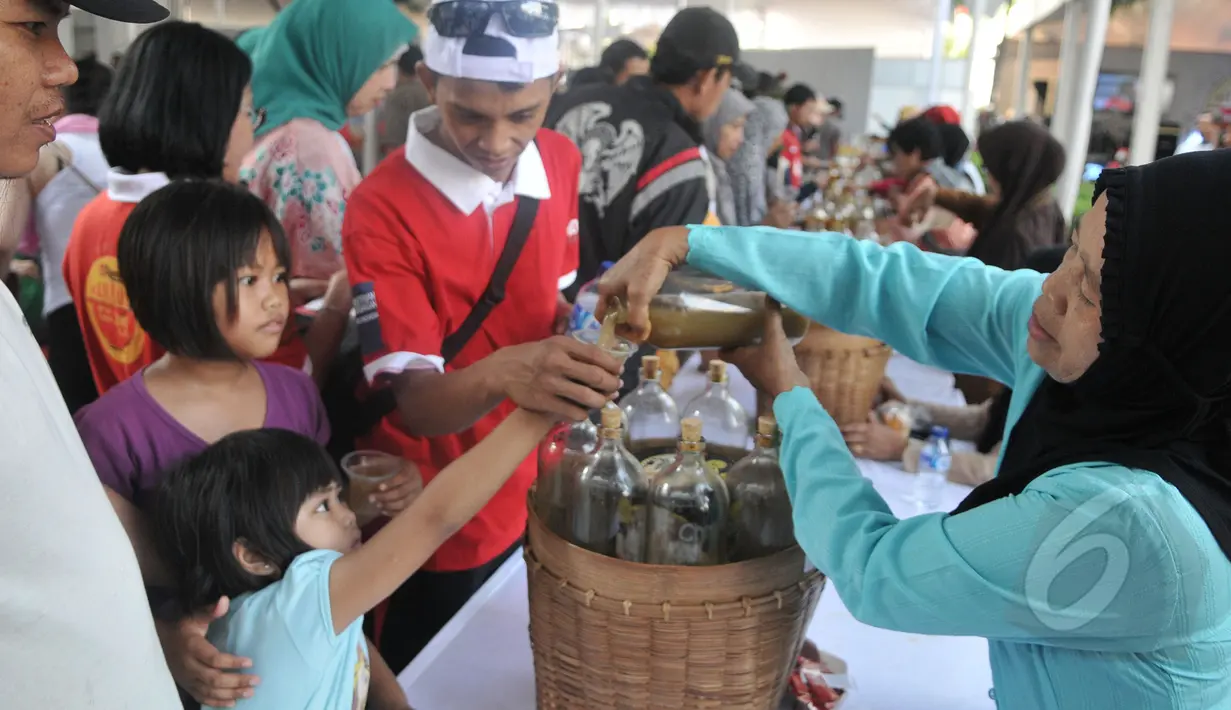Sejumlah bocah meminta jamu saat peringatan Hari Konsumen Nasional di Lapangan Parkir Gedung Sarinah, Jakarta, Minggu (10/5/2015). (Liputan6.com/Herman Zakharia) 