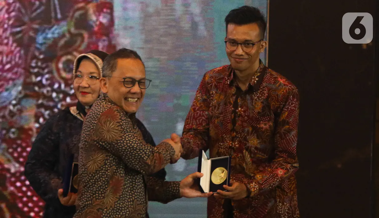 Kepala BRIN Laksana Tri Handoko memberikan plakat kepada Naufan Noordyanto, SSn, MSn saat Habibie Prize di gedung BJ Habibie, Jakarta, Kamis (10/11/2022). Penghargaan diberikan kepada mereka secara perorangan yang mempunyai kontribusi aktif di bidang ilmu pengetahuan dan teknologi (Iptek) serta inovasi. (Liputan6.com/Herman Zakharia)
