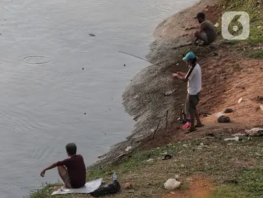 Warga melakukan aktivitas mancing di Kanal Banjir Barat, Jakarta, Selasa (9/6/2020). Fase pertama PSBB transisi di Ibukota dimanfaatkan warga untuk memancing. (Liputan6.com/Johan Tallo)