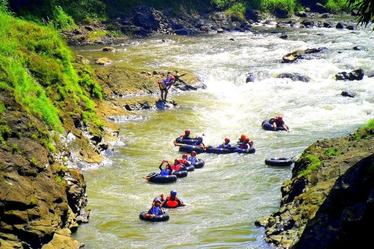 Tubing menyusuri derasnya aliran sungai Klawing. (Liputan6.com/Dinkominfo PBG/Muhamad Ridlo)