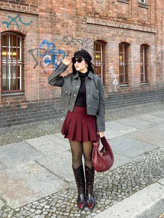 Sebagai sentuhan feminin, ia kenakan rok mini ruffle merah dengan stocking dan high boots burgundy [@febbyrastanty]